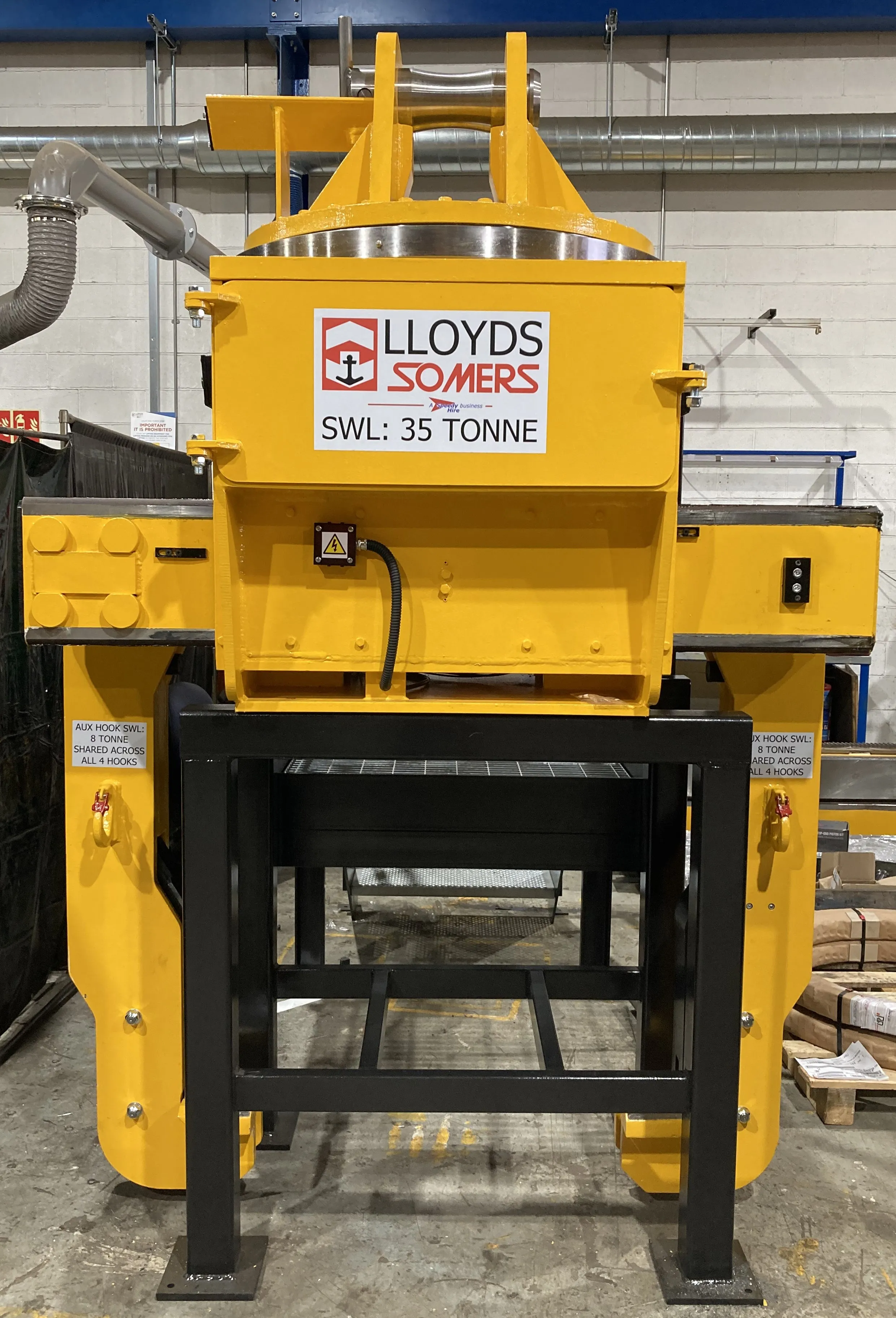 Yellow Somers-branded coil tong gripping a steel coil, heavy-section mill-duty equipment.
