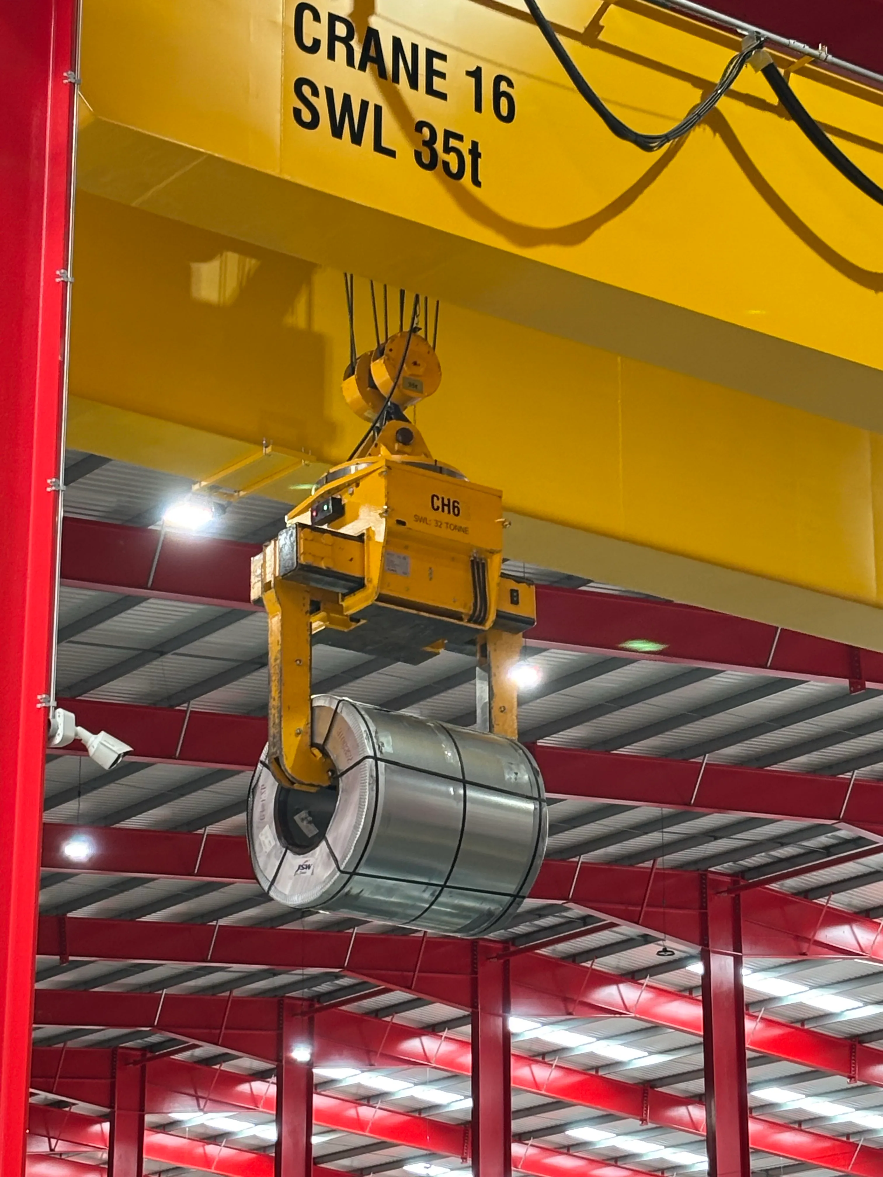 Yellow Somers-branded coil tong gripping a steel coil, heavy-section mill-duty equipment.