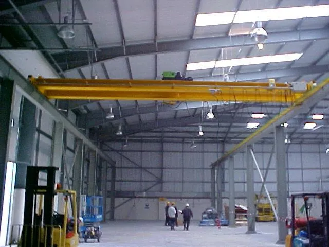 Interior of a Somers production workshop with yellow overhead crane runway — the manufacturing capacity behind the bespoke lifting equipment we supply to construction and civil-engineering programmes.